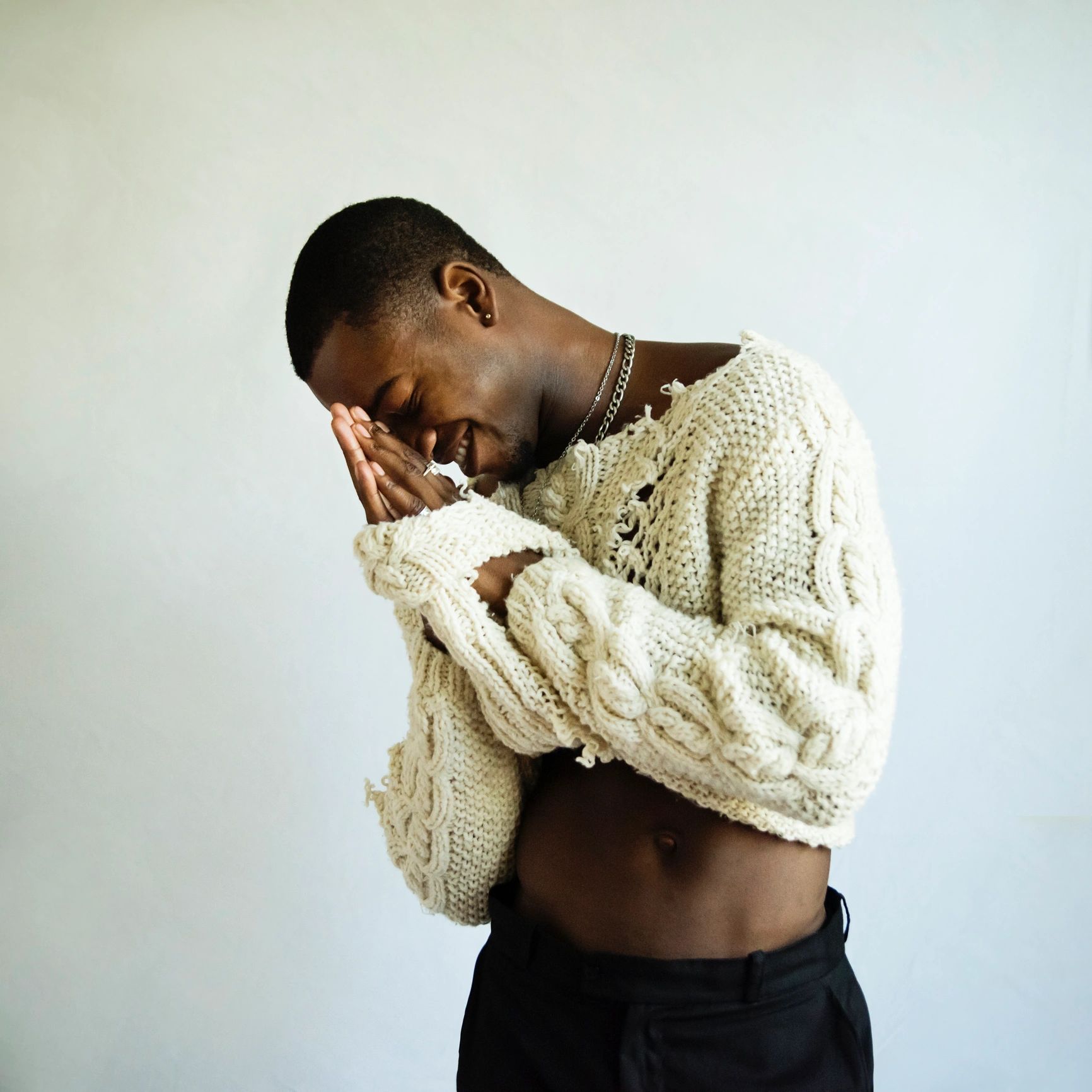 Black male model in a fashion studio wearing a custom streetwear sweater